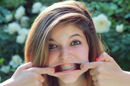 Teenage girl makes a funny face with braces on