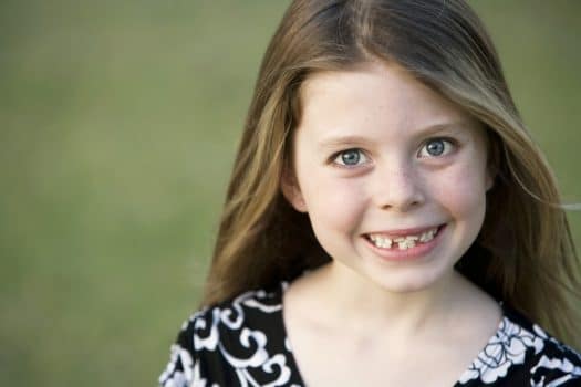 Young girl with crooked teeth smiling