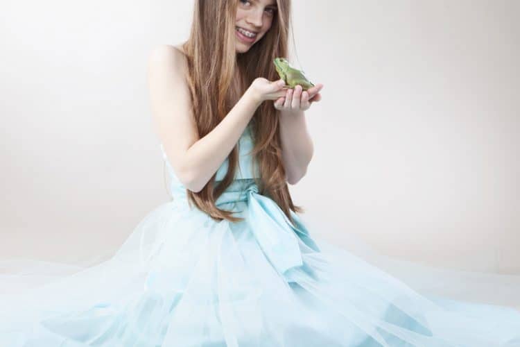 girl with braces about to kiss a frog