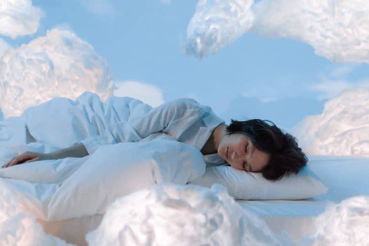 Person sleeping surrounded by clouds on a blue background