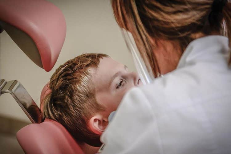 Child in a dental chair with a provider talking to them
